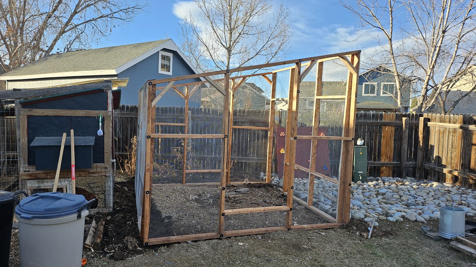The new run framed and wrapped in hardware cloth, standing where the old coop had been.